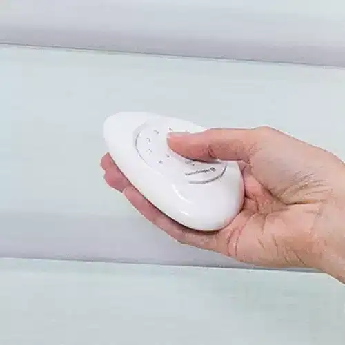 Hand using a handheld device to clean a mattress or surface, ensuring hygiene and stain removal.