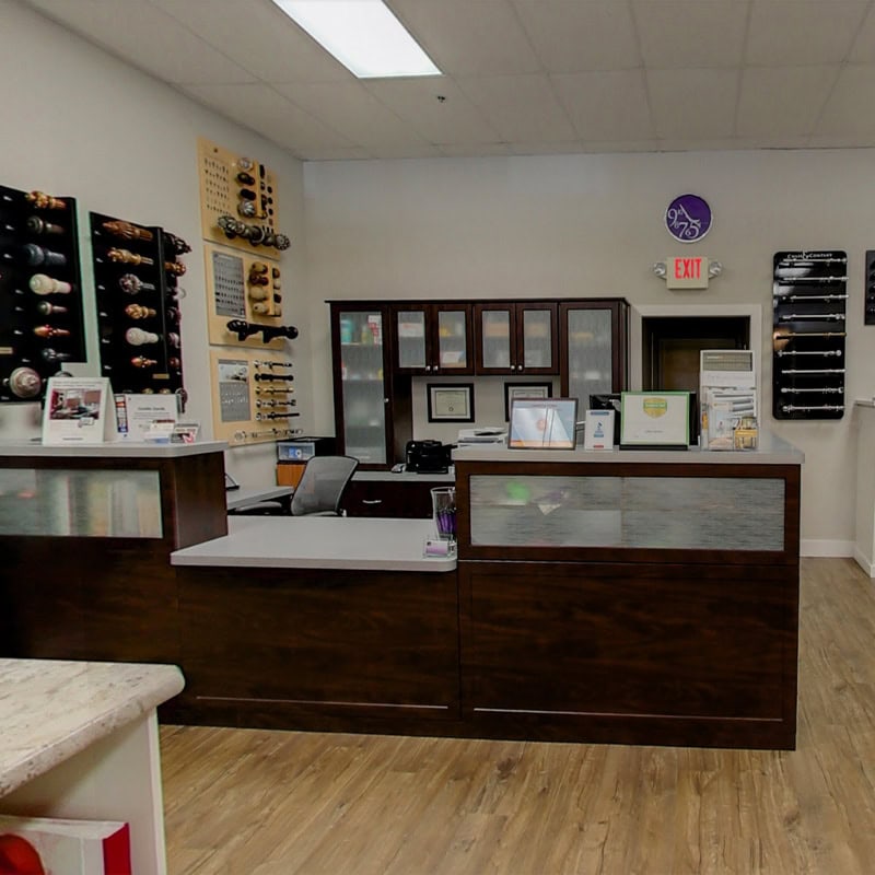 Modern wine shop interior with wine bottles displayed on wall racks and a reception counter.