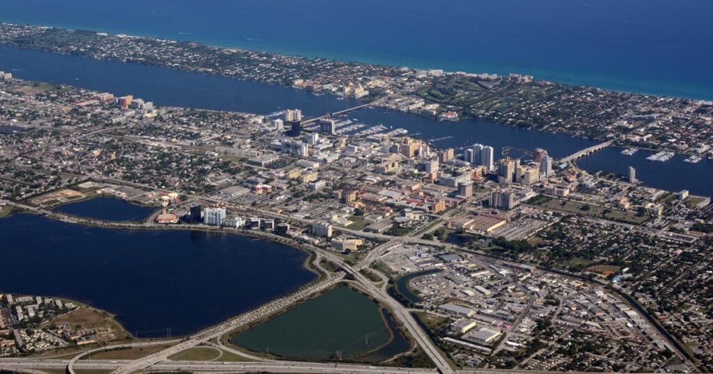 Aerial view of Palm Beach County showing waterways, cityscape, and coastline with urban and natural areas.