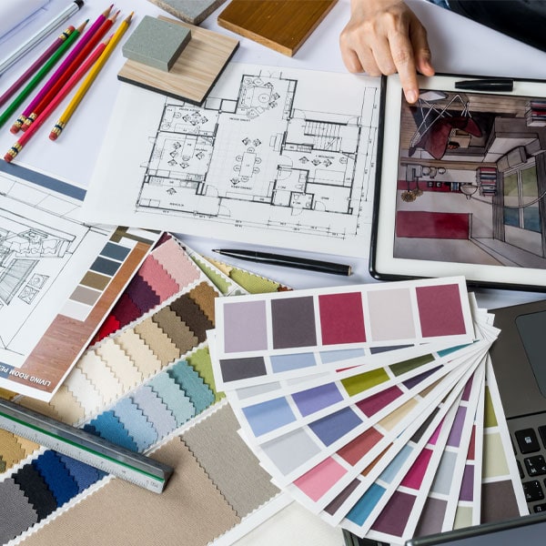 Interior design workspace with floor plans, color swatches, and digital renderings for home renovation.